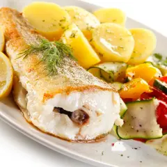 Smażona ryba z ziemniakami, cytryną i warzywami. Idealne danie, by sprawdzić, co zjeść w Świnoujściu.