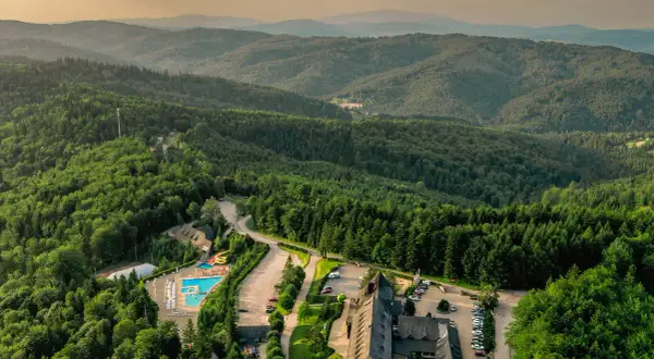 Malowniczy hotel dla dorosłych w górach, otoczony lasem, z basenem i zjeżdżalnią. Idealne miejsce na relaks.