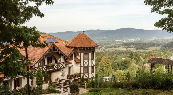 Hotel Karpacz Dziki Potok z charakterystyczną architekturą i widokiem na góry.