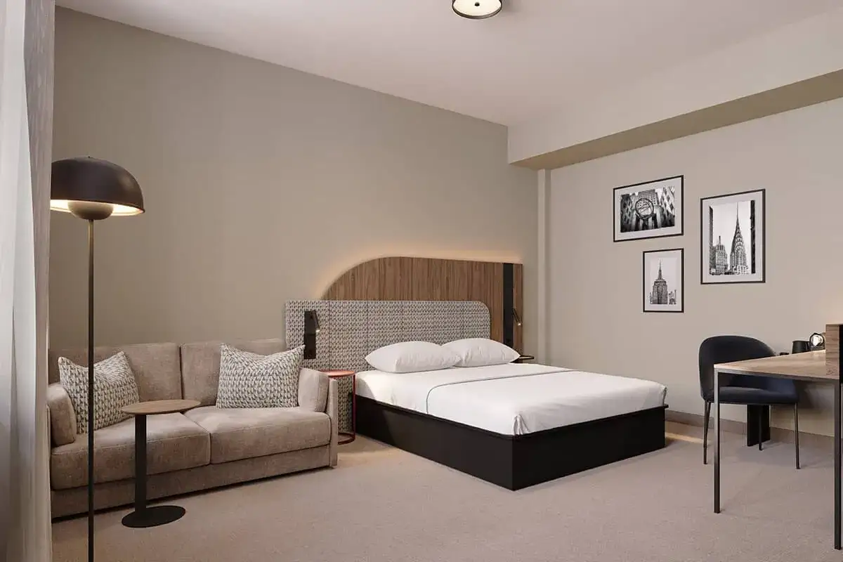 Nowoczesny pokój hotelowy z wygodną sofą i łóżkiem. Odkryj najnowsze hotele w Polsce, oferujące komfort i styl.