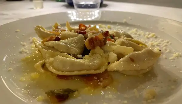 Pyszne pierożki z ricottą i szpinakiem, posypane parmezanem. Idealne pytanie: co zjeść w Bergamo?